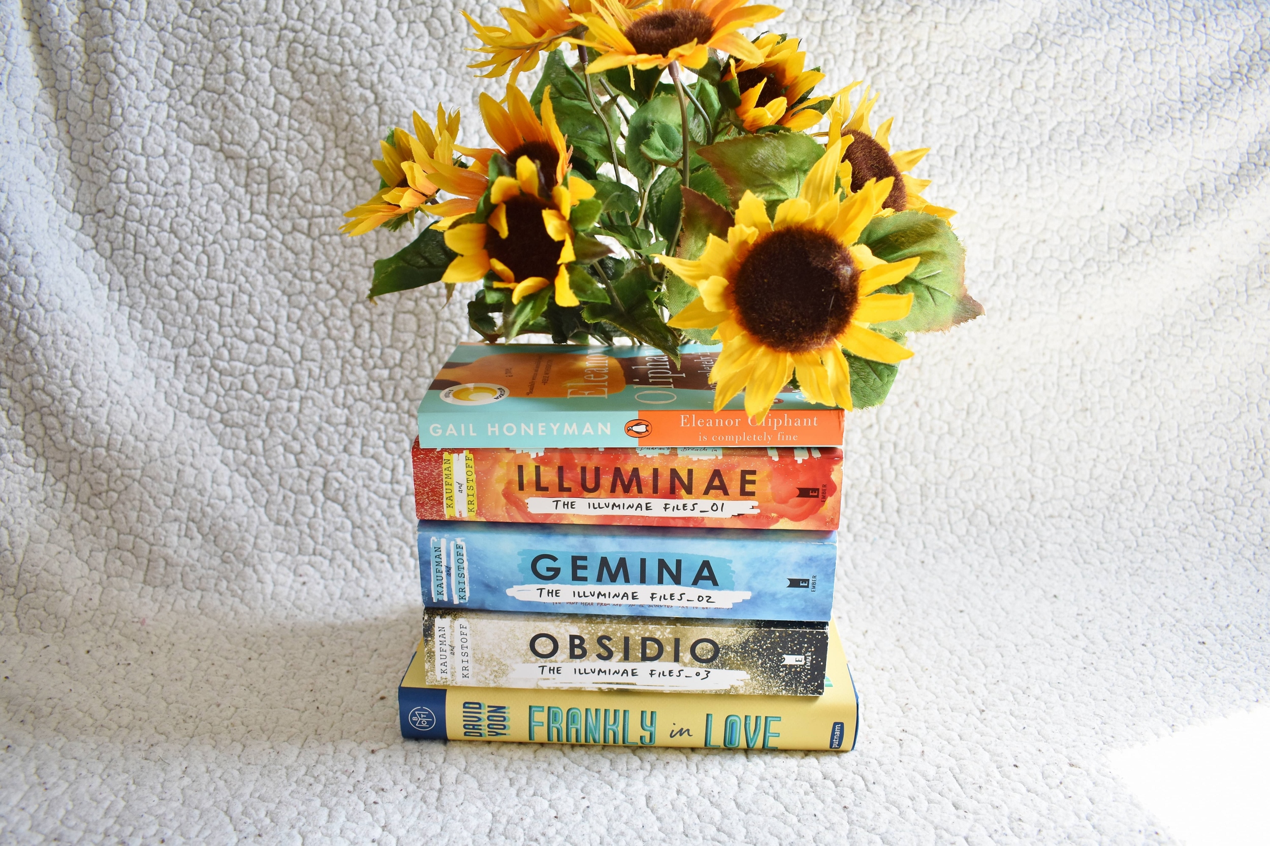 stack of books with sunflowers